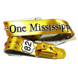 A metallic gold leather guitar strap featuring Kidskin overlays, gold studs and stars and Swarovski Crystals. There is a custom leather wireless transmitter pocket on the back.