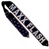 A black leather guitar strap with cream metallic kidskin overlays, distressed silver metallic details, and Swarovski crystals on the lettering.